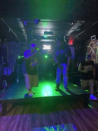 a group of people standing on a stage in a dark room